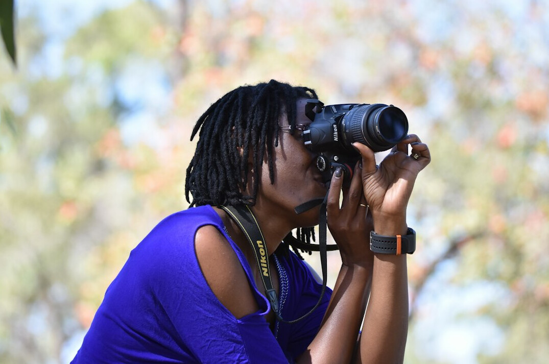 Studio portrait of an Indigenous Canadian woman photographer with a camera